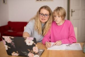 girl in pink sweater beside parent in gray sweater
