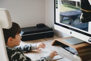 boy in black and white sweater watching computer screen age appropriate